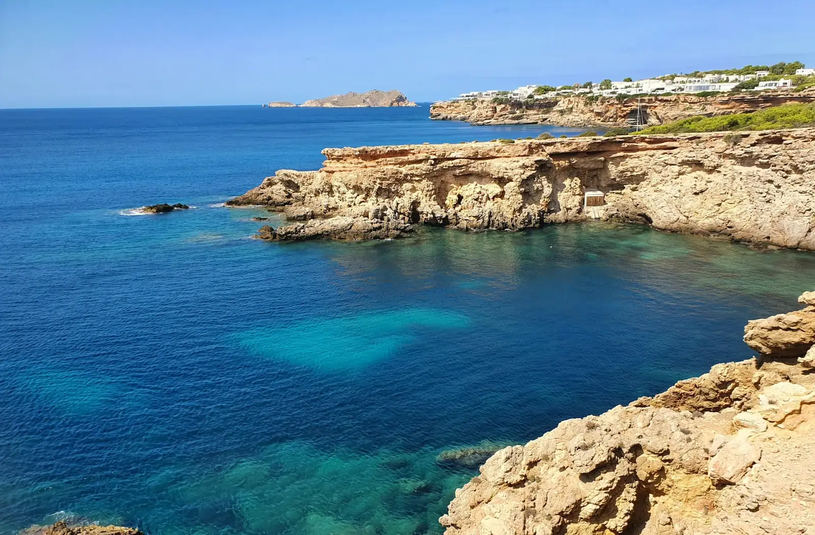 Costa mediterrânica de Ibiza com mar, falésias e casas brancas